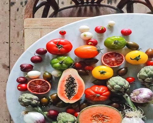 Assorted fresh green vegetables and fruits on a rustic table